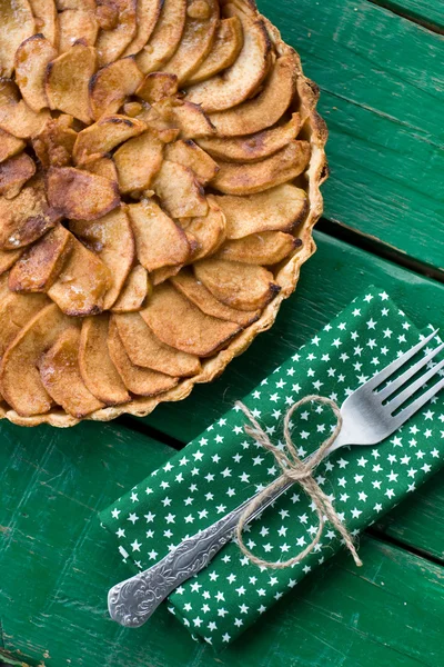 Tarte aux pommes juteuse à la cannelle et au brandy sur fond vert — Photo