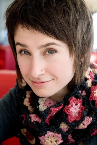 Portret van een mooie jonge brunette in een gebreide sjaal — Stockfoto