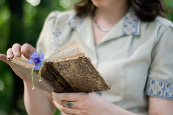 Une jeune fille en robe vintage tenant un vieux livre — Photo