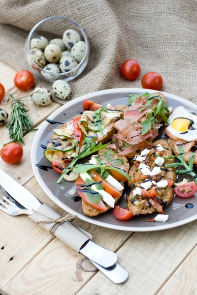 Muitos deliciosos bruschetta com queijo, tomate, ovo de codorna, presunto, s — Fotografia de Stock