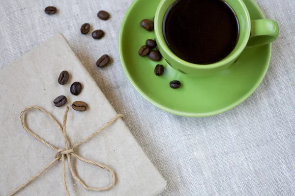 Groene kopje koffie met koffiebonen en vintage notebook — Stockfoto