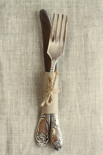 Vintage knife and fork on the tablecloth on light background — Stock Photo, Image