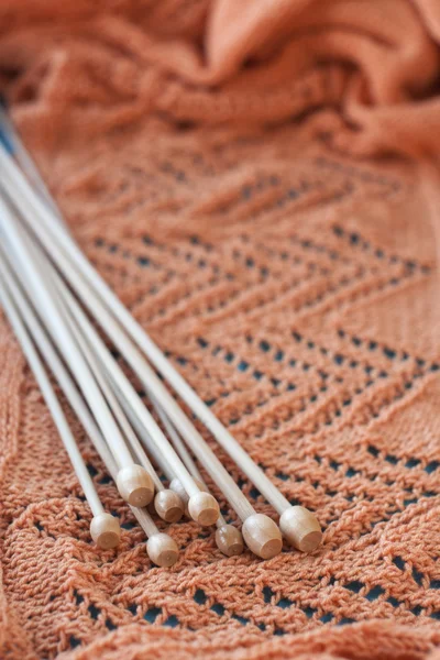 Veel houten spaken liggen op een oranje gebreide plaid — Stockfoto