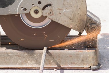 Öğütücüyle metal kesen bir işçi