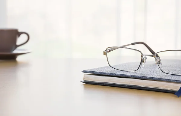 Bril en een boek op het Bureau — Stockfoto