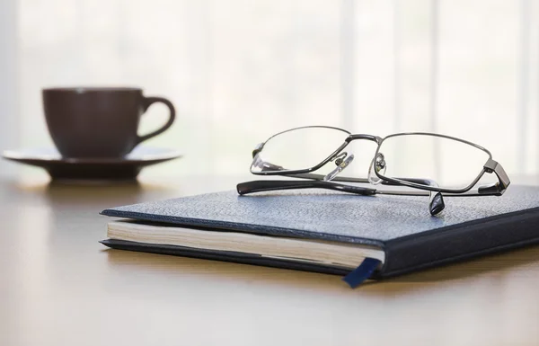 Bril en een boek op het Bureau — Stockfoto