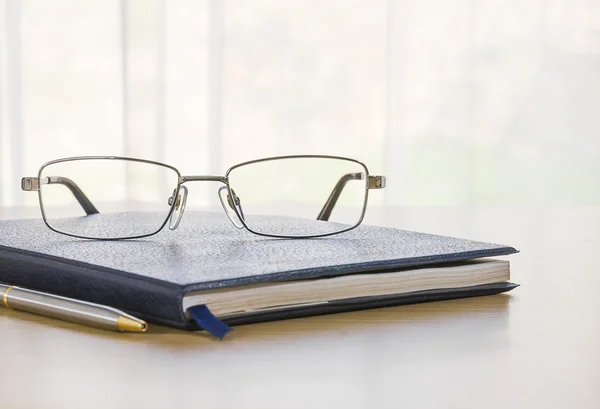 Bril en een boek op het Bureau — Stockfoto