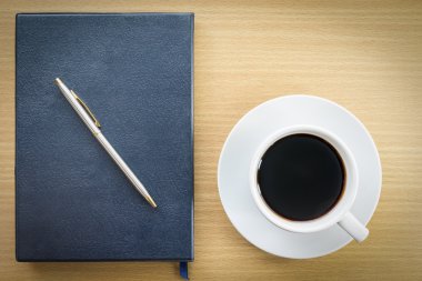sehpanın üzerinde kahve ve defter