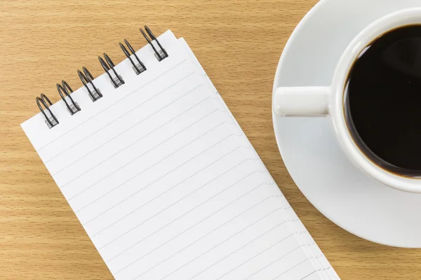 Coffee and notepad on wood table — Stock Photo, Image