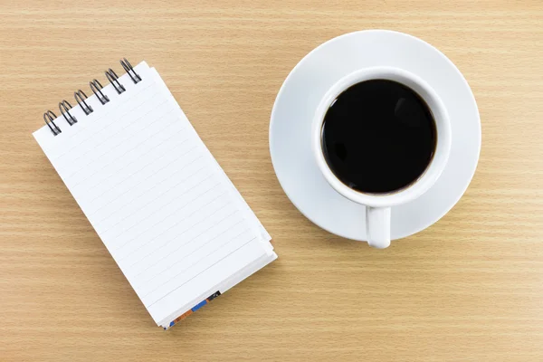 Coffee and notepad on wood table — Stock Photo, Image