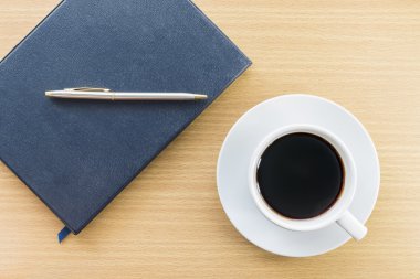 sehpanın üzerinde kahve ve defter