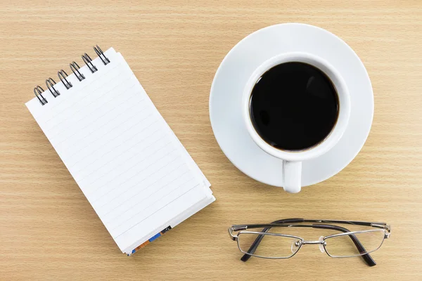 Coffee and notepad on wood table — Stock Photo, Image