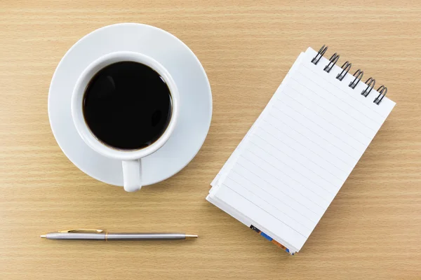 Coffee and notepad on wood table — Stock Photo, Image