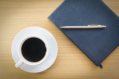 sehpanın üzerinde kahve ve defter