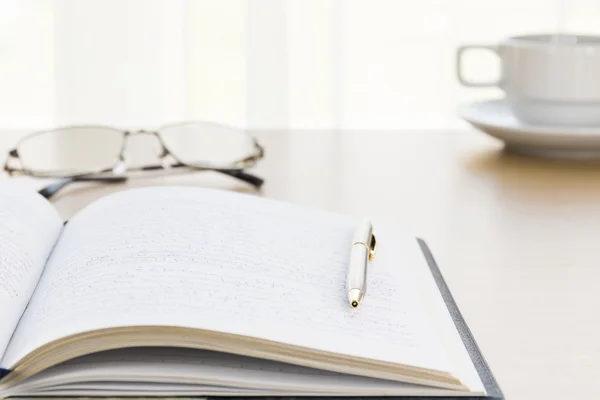 Pen op een boek met op het Bureau zetten — Stockfoto