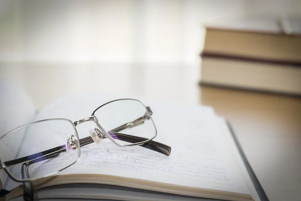 Brillen zet op notitieblok op houten tafel — Stockfoto