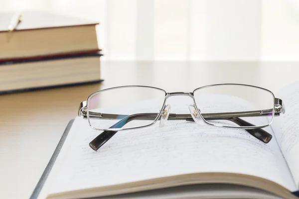 Brillen zet op notitieblok op houten tafel — Stockfoto