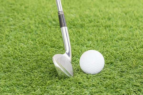Golf ball and golf club on green grass — Stock Photo, Image