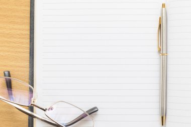 Gözlük ve notepad ile boş bir sayfa üzerinde kalem