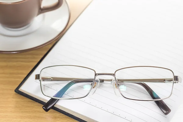 Brillen zet op notitie pad openen lege pagina — Stockfoto