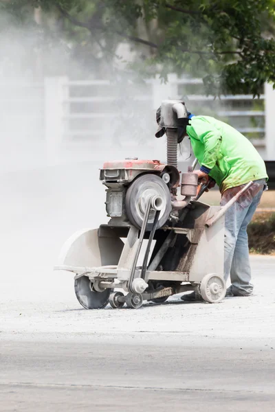 Arbeiter sägt Asphaltstraße ab — Stockfoto