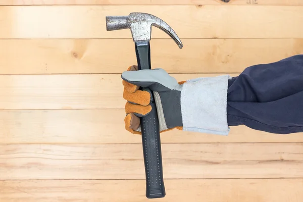 Mano en guante sosteniendo el martillo — Foto de Stock