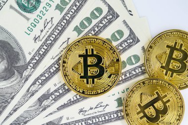 Bitcoins madeni parası ve 100 dolarlık banknotlar. Metal parlayan bitcoin şifreleme paraları ve Amerikan dolarını kapat