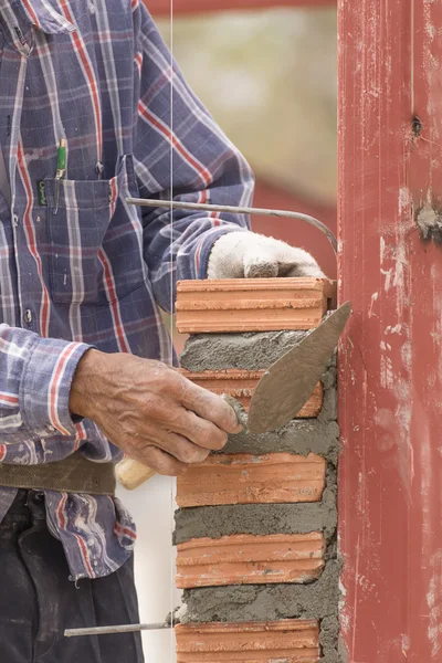 Maurer arbeitet auf der Baustelle der Ziegelmauer — Stockfoto