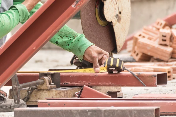 Arbeiter schneidet Metall mit Schleifer auf Baustelle — Stockfoto