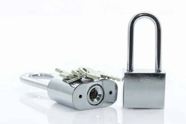 Metalliska hänglås med nycklar på vit bakgrund — Stockfoto