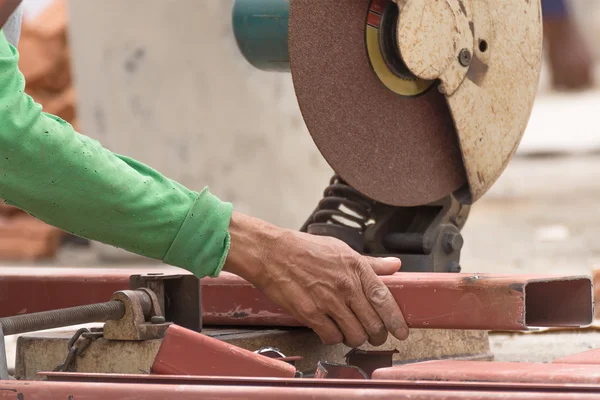 Trabalhador de corte de metal com moedor no canteiro de obras — Fotografia de Stock