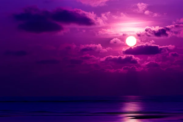 Dramatische zonsondergang achter de wolken boven de zee — Stockfoto