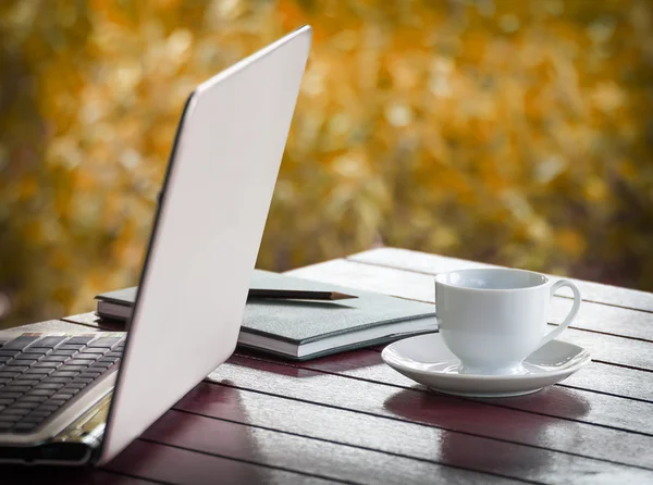 Laptop i filiżankę kawy na biurko — Zdjęcie stockowe
