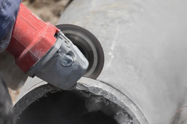 Loodgieters snijden betonnen leidingen voor water — Stockfoto