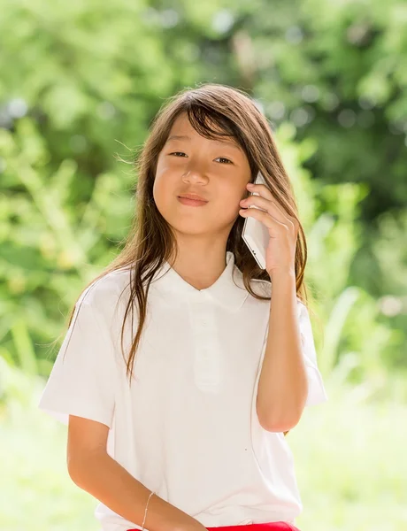 Asia chica uso de teléfono inteligente en el jardín —  Fotos de Stock