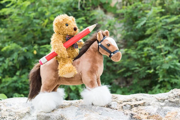 Плюшевий ведмідь катається на коні в лісі — стокове фото