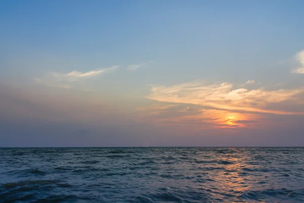 Sunset over the sea with clouds over the water surface — Stock Photo, Image