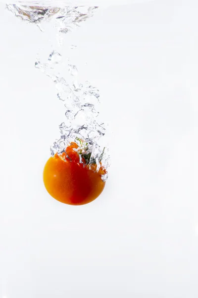 Red tomato splashing in water — Stock Photo, Image