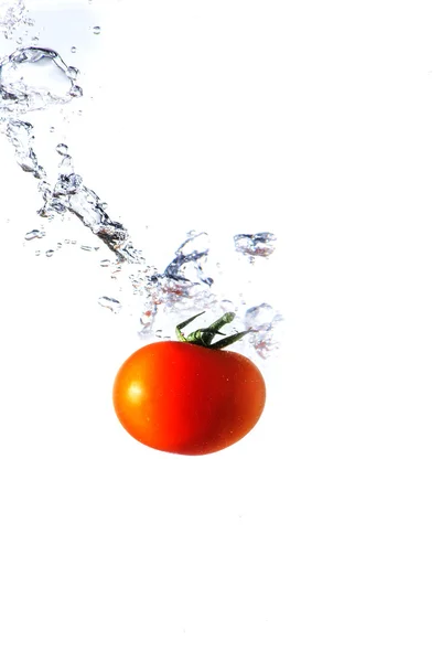 Red tomato splashing in water — Stock Photo, Image