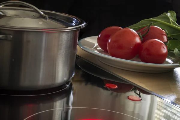 Topf auf dem Feuer, Tomaten und Salat — Stockfoto