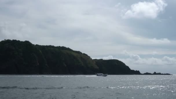 Barco flotante y tropical isla en el fondo — Vídeo de stock