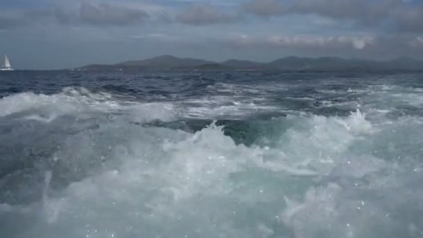 Поход на лодке. Вид на волны и спускающуюся яхту издалека — стоковое видео