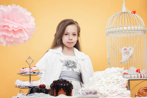 Lovely girl posing with sweet treats in studio — Stock Photo, Image