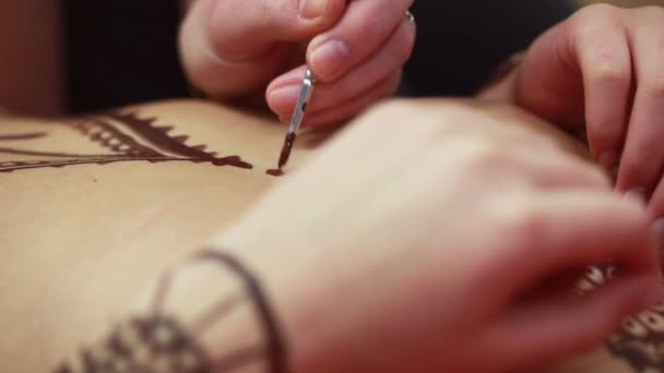 Мастер живописи с хной на теле девушки — стоковое видео