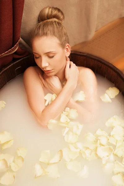 사랑 스러운 여자 장미 꽃잎으로 목욕을 편안 하 게 즐긴다 — 스톡 사진