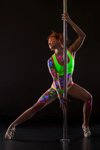 Sexy pole dancer with glowing patterns on her body — Stock Photo, Image