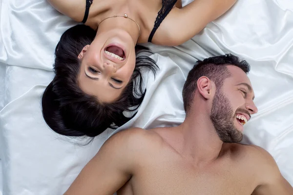 Bovenaanzicht van een liefdevol paar lachen in bed — Stockfoto