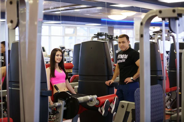 Spor salonunda. Fitness Eğitmeni ve kız kameraya poz — Stok fotoğraf