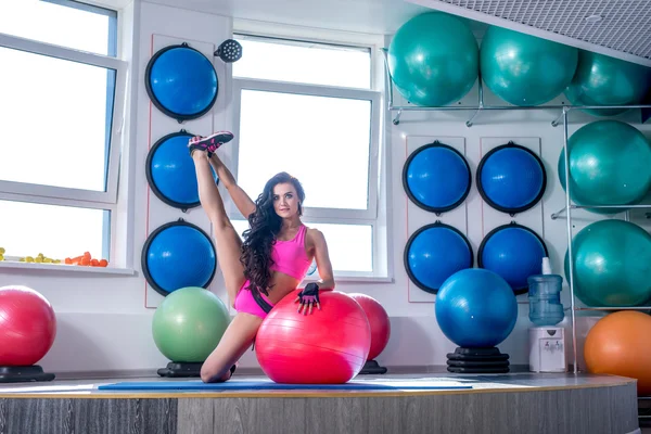 Beautiful sporty woman trains in modern gym — Stock Photo, Image