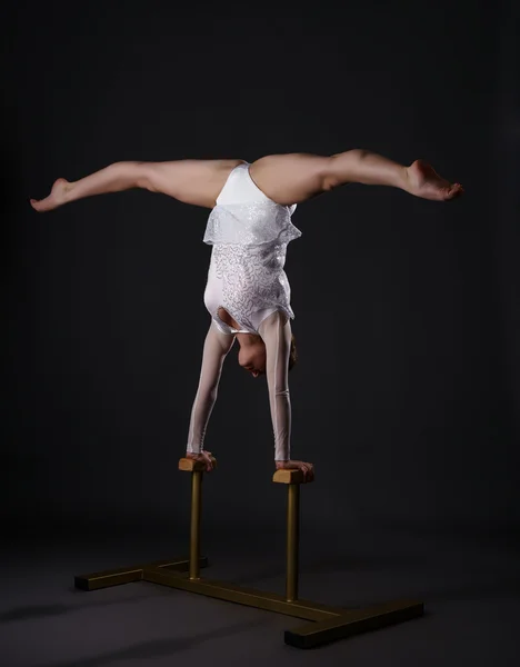 Charming gymnast doing handstand on circus stands — Stock Photo, Image
